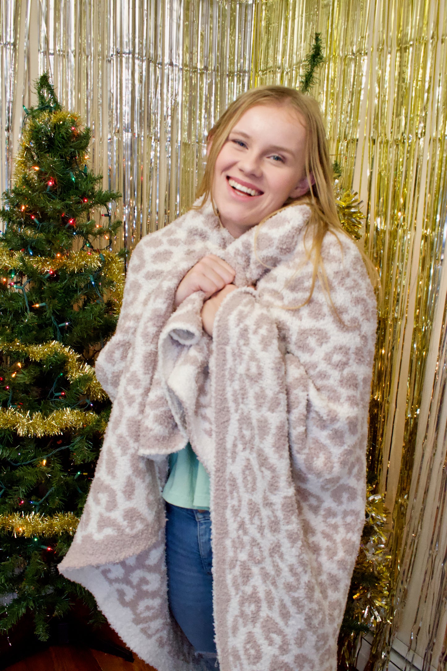 Model holding cheetah print throw blanket