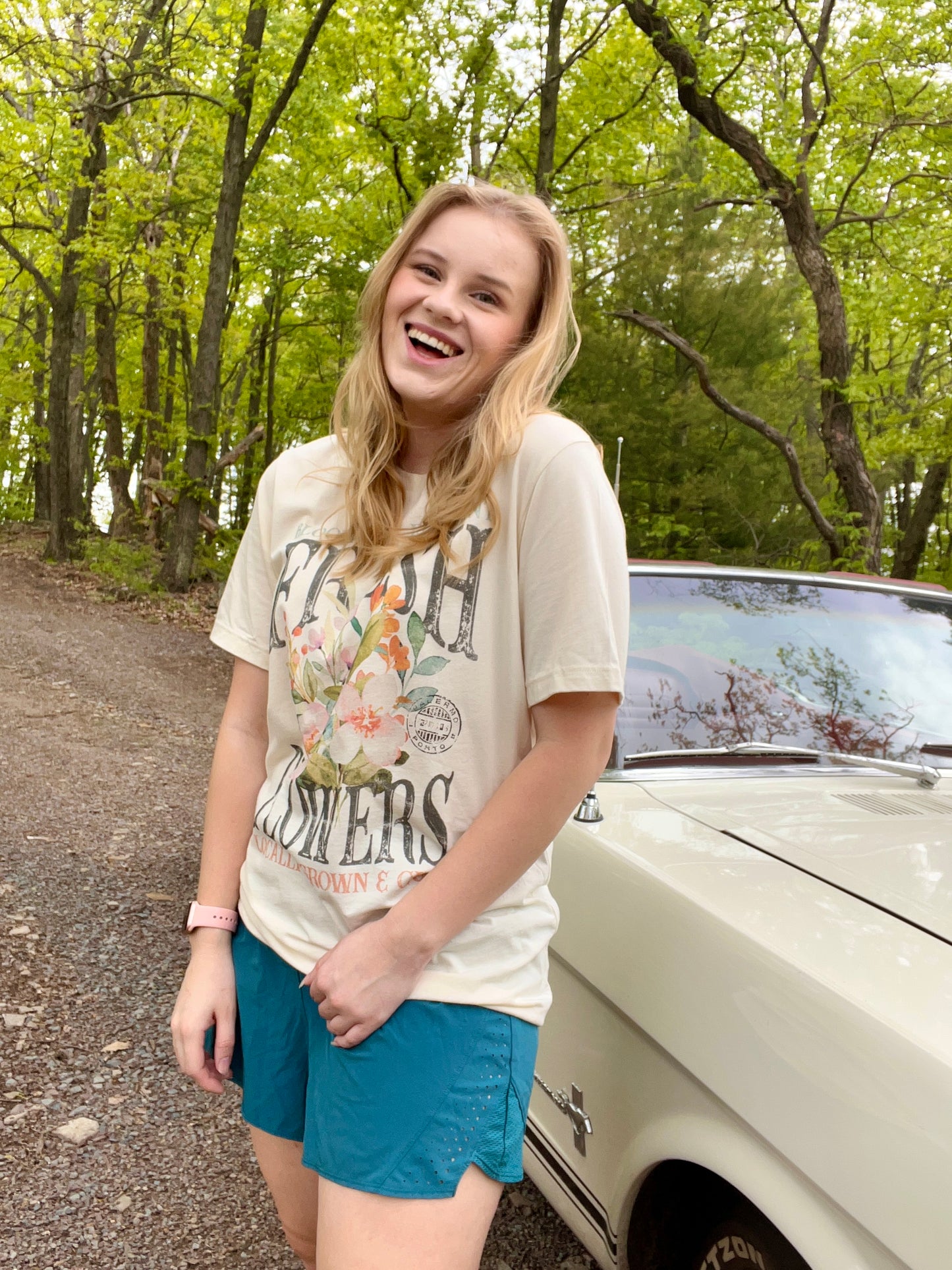 Woman modeling a vintage oversized beige graphic tee with a design featuring the words "Fresh Flowers" and a design of flowers