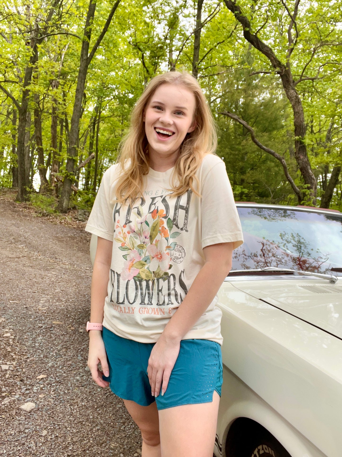 Woman modeling a vintage oversized beige graphic tee with a design featuring the words "Fresh Flowers" and a design of flowers