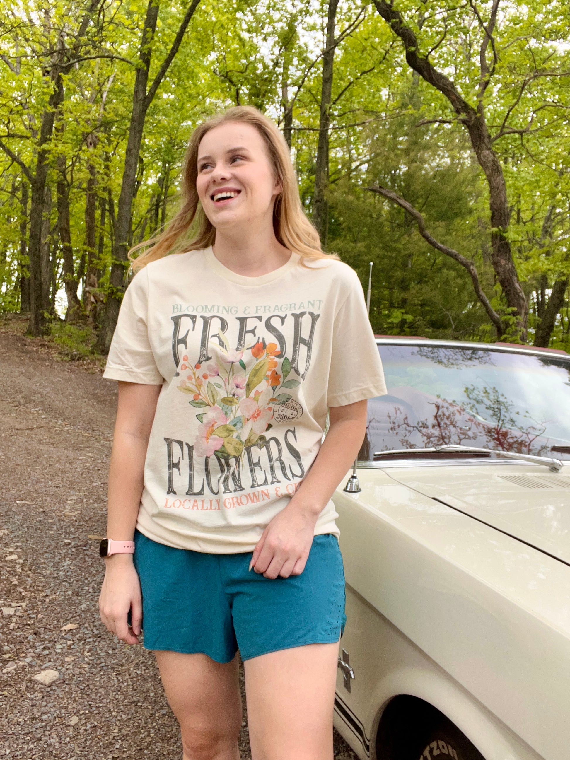 Woman modeling a vintage oversized beige graphic tee with a design featuring the words "Fresh Flowers" and a design of flowers